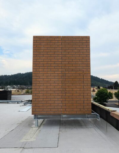 Finished rooftop telecom concealment structures designed to match the existing building